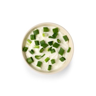 Beyaz arka planda yeşil soğanlı bir kase lezzetli ekşi krema