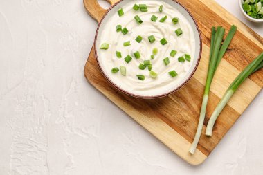 Hafif arka planda yeşil soğanlı bir kase lezzetli ekşi krema.