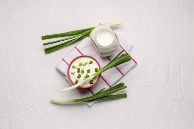 Hafif arka planda yeşil soğanlı bir kase lezzetli ekşi krema.