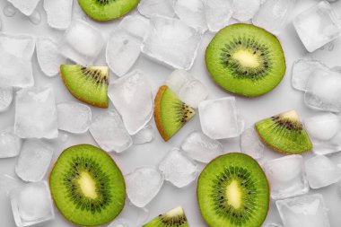 Gri arkaplanda taze kivi ve buz dilimlenmiş.