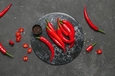 Koyu arkaplanda taze kırmızı biberli tahta.