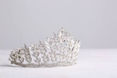 Beautiful tiara on white table, closeup. Prom concept