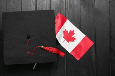 Koyu arkaplanda mezuniyet şapkası olan Kanada bayrağı