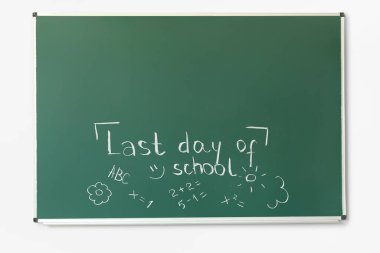 Okulun son günü yazılı karatahta ve beyaz duvardaki çizimler