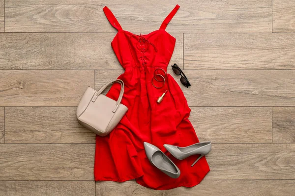 Red dress with accessories and heels on wooden floor