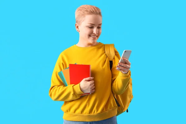 Estudante Com Cadernos Usando Telefone Celular Fundo Azul — Fotografia de Stock