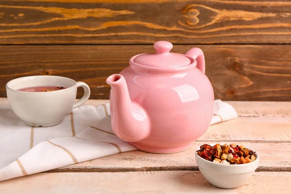 stock image Ceramic teapot with cup of tea and dried fruits on white wooden table