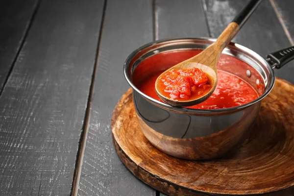 Saucepan Łyżka Smacznym Sosem Pomidorowym Ciemnym Drewnianym Tle — Zdjęcie stockowe