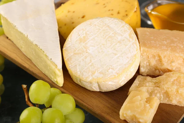 桌子上有不同类型奶酪的木板 — 图库照片