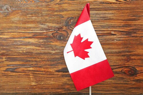 Flag of Canada on dark wooden background, closeup