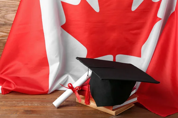 Absolventský Klobouk Diplomem Knihami Vlajkou Kanady Dřevěném Stole — Stock fotografie