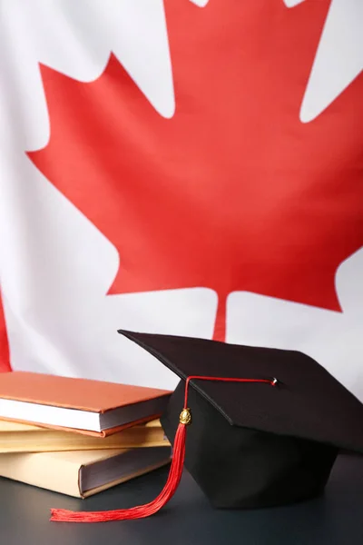 Maturitní Klobouk Knihami Stole Proti Vlajce Kanady — Stock fotografie