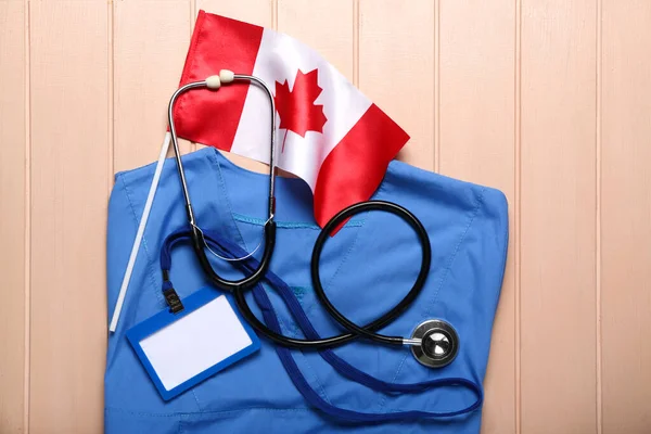 Canadian Flag Doctor Uniform Badge Stethoscope Beige Wooden Background — Stock Photo, Image