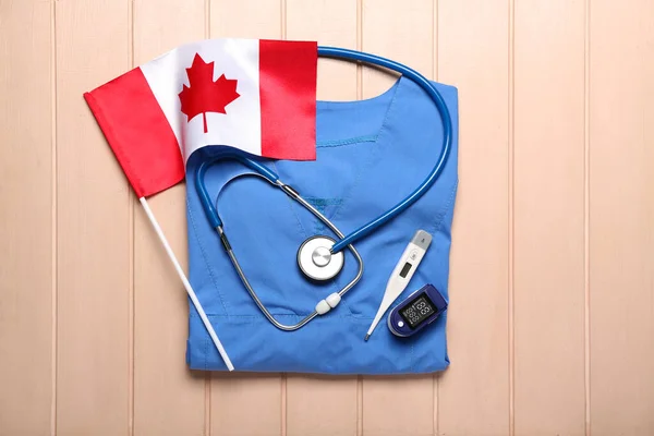 Canadian Flag Doctor Uniform Thermometer Pulse Oximeter Stethoscope Beige Wooden — Stock Photo, Image