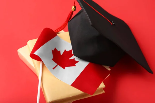Kanadská Vlajka Maturitní Klobouk Knihy Červeném Pozadí — Stock fotografie