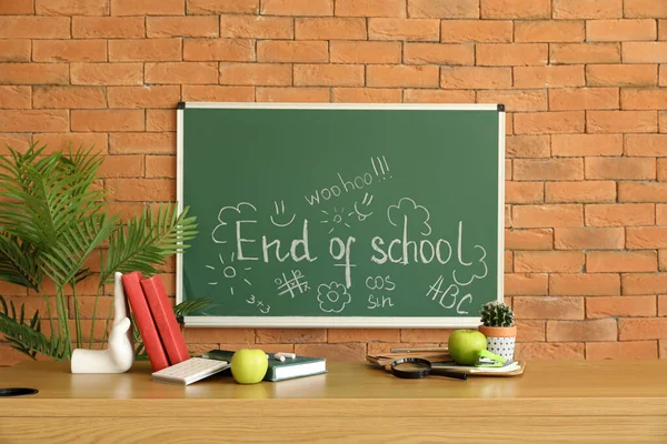 Blackboard with text END OF SCHOOL and drawings in classroom