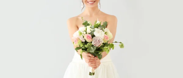 美丽的年轻新娘与花束在光背景 — 图库照片