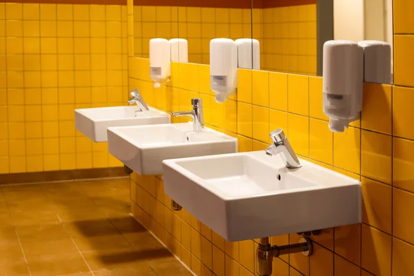 公衆トイレの自動ソープディスペンサー付きシンクの眺め — ストック写真