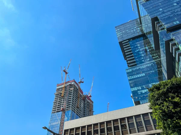 都市の建設クレーンと未完成の複数階建ての建物の眺め — ストック写真