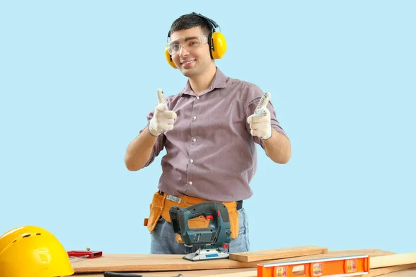 Jovem Carpinteiro Protetores Auditivos Mostrando Polegares Para Cima Mesa Fundo — Fotografia de Stock