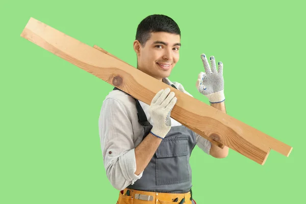 Jovem Carpinteiro Com Pranchas Madeira Mostrando Fundo Verde — Fotografia de Stock