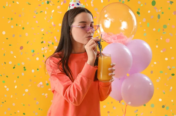 在黄色背景下 快乐的年轻女子与鸡尾酒庆祝生日 — 图库照片