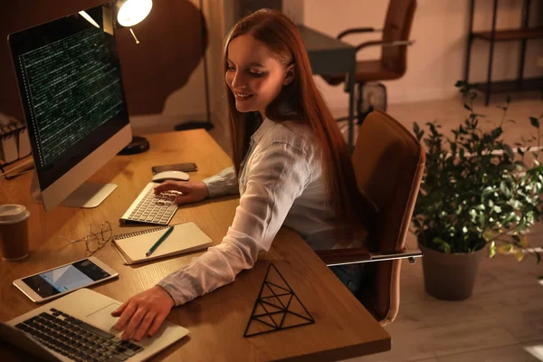 夜にオフィスでノートパソコンを扱う女性プログラマー — ストック写真