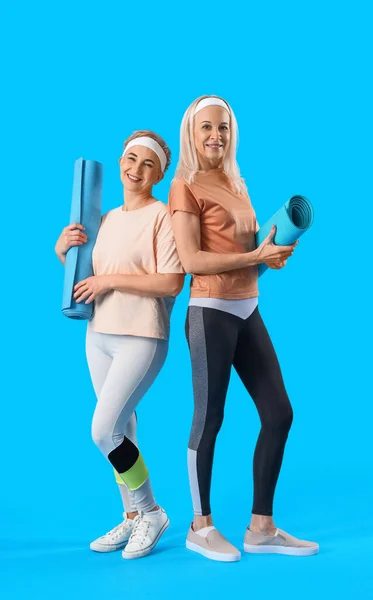 有蓝色背景瑜伽垫的体形丰满的成熟女性 — 图库照片
