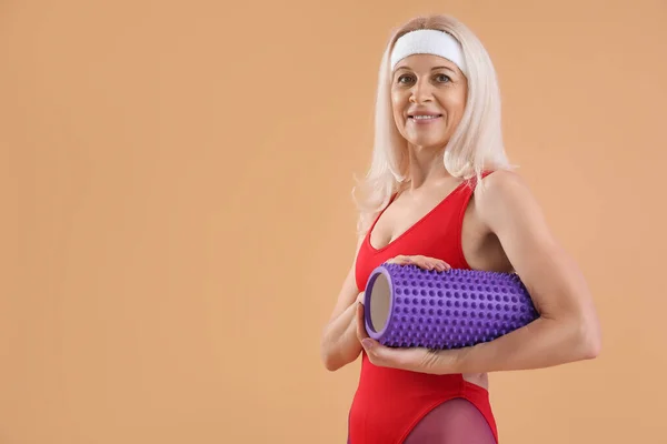 Sporty Mature Woman Foam Roller Beige Background — Stock Photo, Image