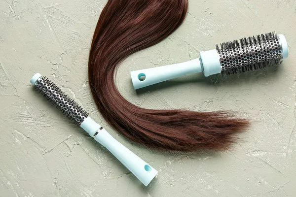 Brown hair with round brushes on grunge background