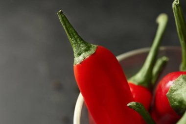 Koyu arkaplanda bir bardak taze biber, yakın plan.