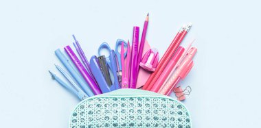 Açık mavi arkaplanda renkli kırtasiyeli kalem çantası