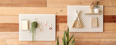 Odanın ahşap duvarına asılı tahta tahtalar, defterler, ev bitkileri ve dekorlar