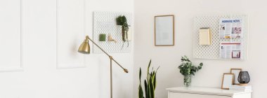 Panolarda gazete, defter, lamba ve çiçeklerin asılı durması.