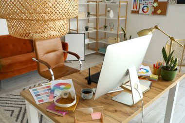 Ofisinde bilgisayar ve boya paletleri olan grafik tasarımcısının çalışma yeri