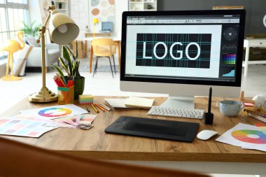 Ofiste bilgisayar, tablet ve boya paletleri ile grafik tasarımcısının çalışma yeri