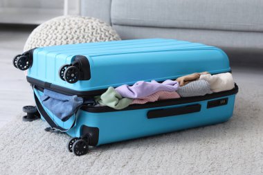 Bavul dolusu kıyafet oturma odasında.