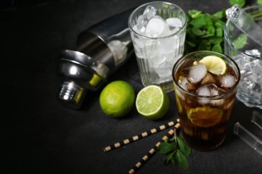 Karanlık arka planda bir bardak soğuk Küba Libre kokteyli.