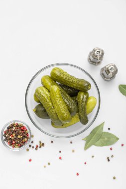 Beyaz arka planda baharatlı bir kase lezzetli salatalık.