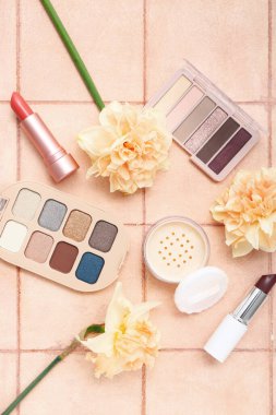 Pembe kaplamalı farklı kozmetik ürünleri olan güzel nergisler.