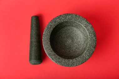 Kırmızı arkaplanda havan ve tokmak