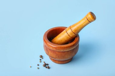 Ahşap harç ve ahşap, mavi arka planda karabiber.