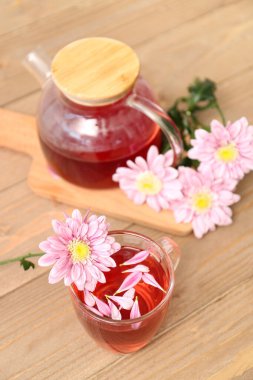 Ahşap masada kasımpatı olan güzel bir çay seti.