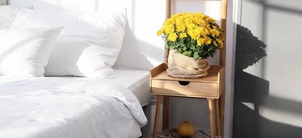 明るい寝室のベッドルームテーブルの上の美しい菊の花 — ストック写真