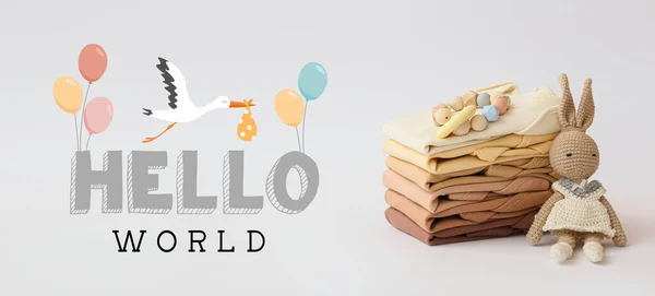 Banner with text HELLO WORLD, baby clothes and toys