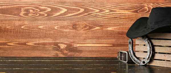 Ковбойская шляпа с коробкой, подковы и поясом на деревянном фоне с пространством для текста