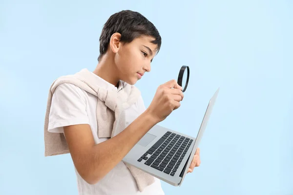 Mały Chłopiec Lupą Laptopem Niebieskim Tle — Zdjęcie stockowe