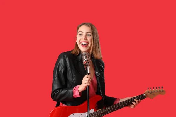 Mujer Joven Con Guitarra Micrófono Cantando Sobre Fondo Rojo — Foto de Stock