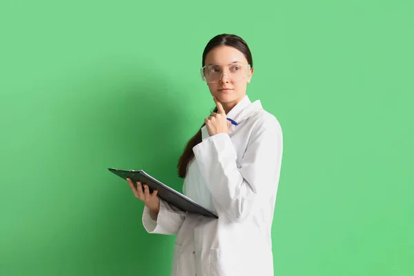 Thoughtful Female Scientist Clipboard Green Background — Stock Photo, Image