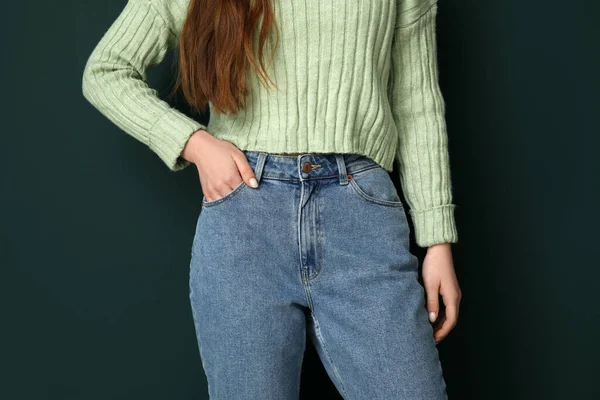 穿着时髦牛仔裤的年轻女子 绿色背景 — 图库照片